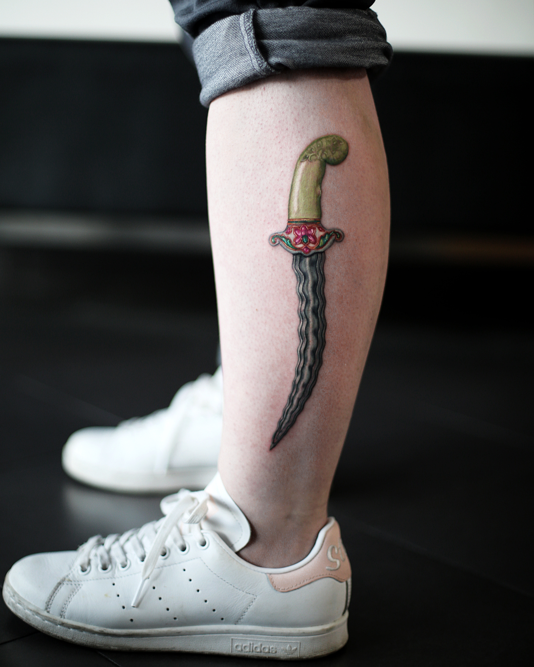Knife tattoo located on the inner arm, blackwork style.